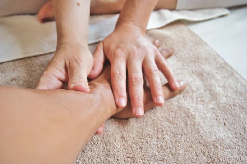 Handmassage op een zachte bruine handdoek